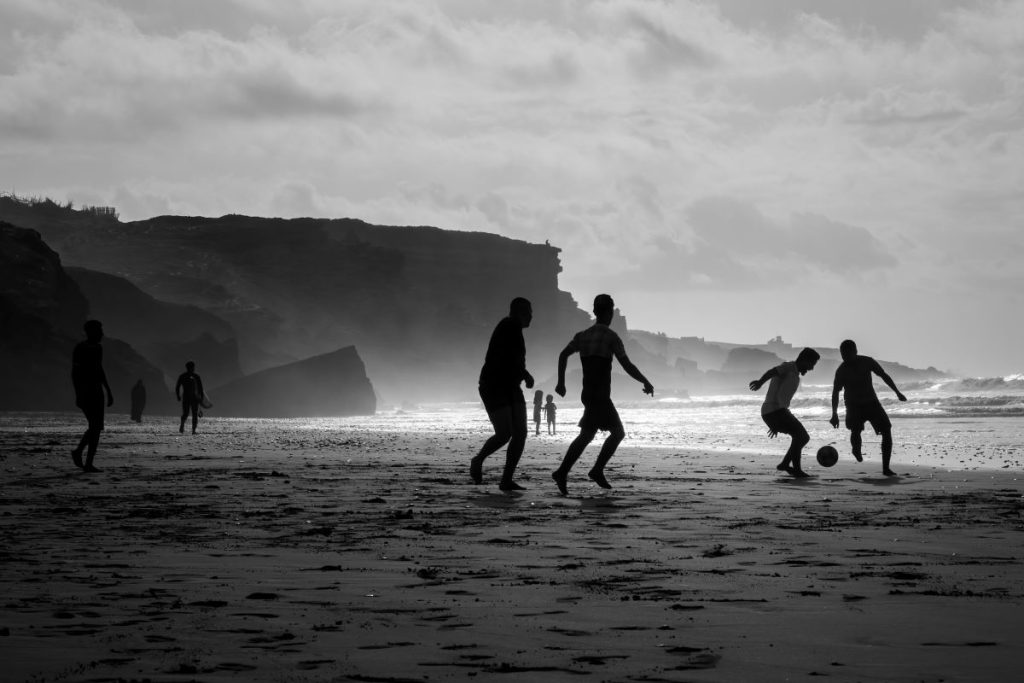 Moroccan youngsters playing football at the shore